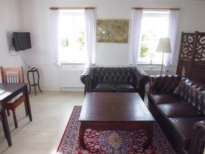 a living room with leather couches and a coffee table at Otel Vaabensted in Sakskøbing