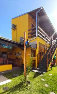 Ein gelbes Gebäude mit einem Mann auf der Treppe in der Unterkunft A Ver o Mar Beach House in Caraguatatuba