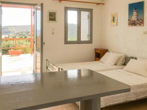 ein Wohnzimmer mit 2 Betten und einem Balkon in der Unterkunft Consolas Gavdos Studios in Gavdos