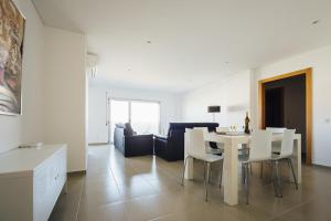 uma sala de jantar e sala de estar com uma mesa branca e cadeiras em Carmona - Holiday Apartments - By SCH em São Martinho do Porto