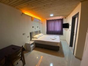 a small bedroom with a bed and a window at Beyoglu Pansiyon in Patara