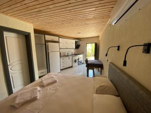 a bedroom with a large bed and a kitchen at Beyoglu Pansiyon in Patara