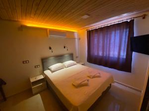 a bedroom with a bed with two towels on it at Beyoglu Pansiyon in Patara