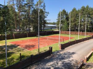 a tennis court with a net on a field at Viking Motel in Hanko