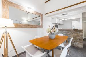 a dining room with a wooden table and white chairs at Duplex in Rue de la Préfecture Old Town 2 Bdrs in Nice