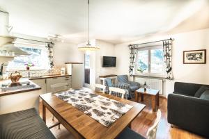 cocina y sala de estar con mesa y sofá en Prà de Metz Apartments, en Santa Cristina Valgardena