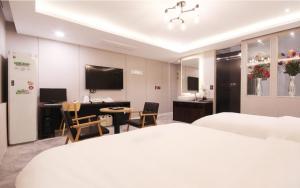 a hotel room with a bed and a desk and a table at Idea Hotel in Pohang