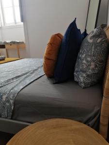 Una cama con almohadas azules encima. en The Portuguese Element en Faro