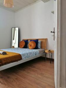 1 dormitorio con cama con almohadas azules y espejo en The Portuguese Element en Faro