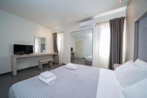 a bedroom with a bed with two towels on it at Makris Yialos Apartments in Lassi