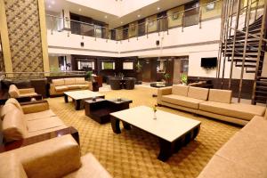 a lobby with couches and tables in a building at HOTEL PITRASHISH PRIDE IGI Intl AIRPORT DELHI in New Delhi