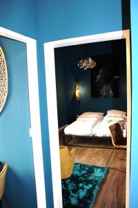 a blue room with a bed and a mirror at a-partment • Urban Living • Köln - Ehrenfeld in Cologne