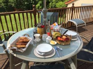 a table with a basket of bread and a basket of fruit at Chambres d' Hotes a Benaize in Coulonges