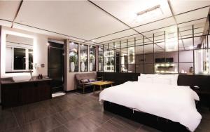 a bedroom with a large white bed and a bathroom at Idea Hotel in Pohang