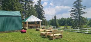 a picnic table in the grass next to a fence at Razvršje Co in Žabljak