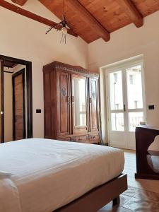 a bedroom with a large bed with a wooden cabinet at ANT Restaurant & Apartments in Novello