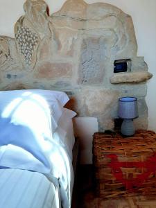 a bedroom with a bed and a stone wall at ANT Restaurant & Apartments in Novello