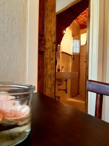een glas water zittend op een tafel met een badkamer bij ANT Restaurant & Apartments in Novello