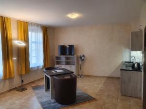ein Wohnzimmer mit einem Tisch und einem TV in einem Zimmer in der Unterkunft Apartments Oberschlesien in Görlitz