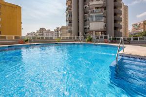 una grande piscina blu di fronte a un edificio di Torre Vistas Superior a Torremolinos