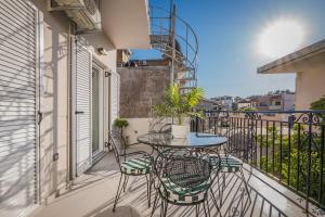 a patio with a table and chairs on a balcony at La Casa Di Luce in Zakynthos Town