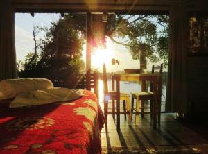 een slaapkamer met een bed, een tafel en een raam bij Casinha RDS in Guarda do Embaú