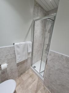 una ducha con puerta de cristal en un baño en The Sea Croft Bed Breakfast & Bar, en Lytham St Annes 113 fotos más