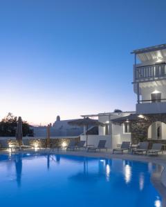 vistas a una piscina con sillas y a un edificio en Mykonos Essence Adults Only, en Ornos