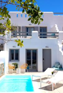 a villa with a swimming pool in front of a house at The Nine Graces - Agia Anna - Option With private pool or hot tub in Agia Anna Naxos