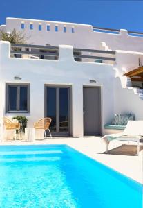 a villa with a swimming pool in front of a house at The Nine Graces - Agia Anna - Option With private pool or hot tub in Agia Anna Naxos
