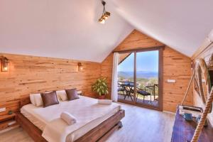 a bedroom with a large bed and a balcony at Ali's Bungalow in Kaş