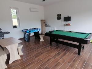 a billiard room with a pool table and tables at ZOLDAV in Nyíradony