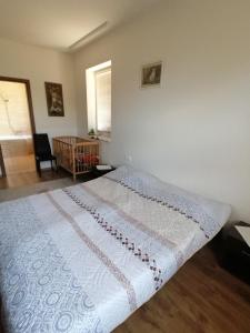ein Schlafzimmer mit einem großen Bett mit einer weißen Decke in der Unterkunft ZOLDAV in Nyíradony