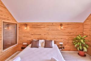 a bedroom with a large bed in a wooden wall at Ali's Bungalow in Kaş +8 photos