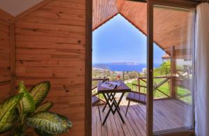 a room with a balcony with a table on a deck at Ali's Bungalow in Kaş
