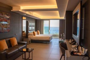 ポルティチにあるHotel & Resort Tre Fontane Luxuryのベッドとソファ付きのホテルルーム