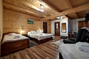 una habitación de hotel con 2 camas y una silla en Magnat Inn & Sauna & Relax, en Zakopane