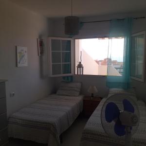 two twin beds in a room with a window at A 300 mètre de la plage plein centre alcossebre in Alcossebre