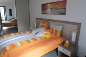 - une chambre dotée d'un grand lit avec une couverture orange et jaune dans l'établissement Apartment - La dolce vita - where dreams come true, à Valledoria