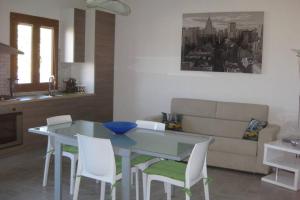 - une cuisine avec une table, des chaises et un canapé dans l'établissement Apartment - La dolce vita - where dreams come true, à Valledoria