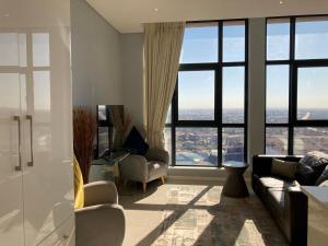 a living room with a view of the city at Urban Awe Apartment-iTowers 23rd Floor in Gaborone