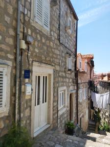 an old stone building with a white door at Rooms Megi in Dubrovnik