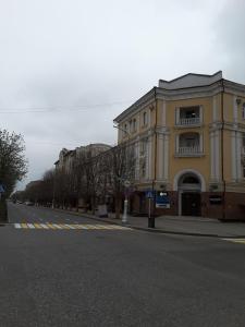 a large yellow building on the side of a street at Отель НОХЧОСТАР in Groznyy
