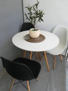a white table and chairs with a plant on it at Aiolos Blu Luxury Apartments in Nea Roda