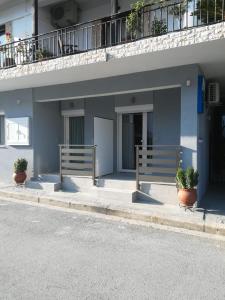 a building with two potted plants in front of it at Aiolos Blu Luxury Apartments in Nea Roda