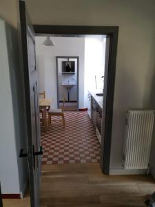a hallway with a door open to a kitchen with a table at Gutshaus Thorstorf FeWo Wismar in Thorstorf
