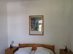 a picture on a wall above a bed with two pillows at Gutshaus Thorstorf FeWo Wismar in Thorstorf