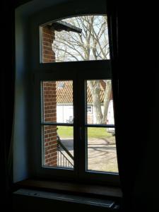 an open window with a view of a yard at Gutshaus Thorstorf FeWo Wismar in Thorstorf
