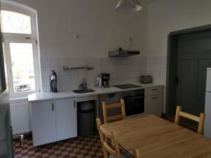 a kitchen with a wooden table and a kitchen with white cabinets at Gutshaus Thorstorf FeWo Wismar in Thorstorf