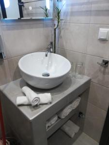 a bathroom with a sink and towels on a counter at Aiolos Blu Luxury Apartments in Nea Roda +53 photos